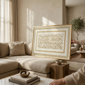 The gold-border Ayat Al-Kursi canvas leaning behind a beige sofa